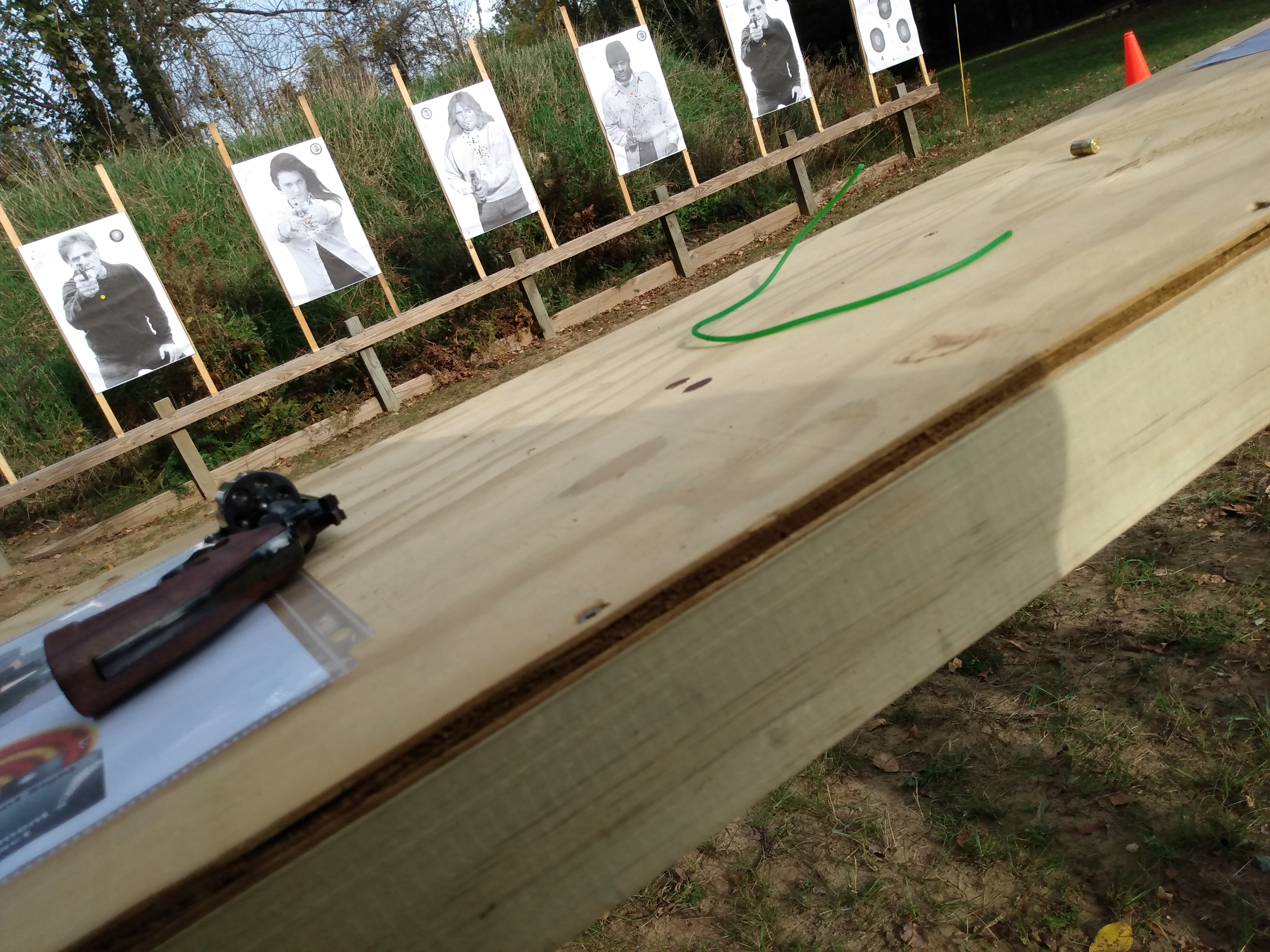 Target downrange of unloaded revolver and instructional reference material on range table